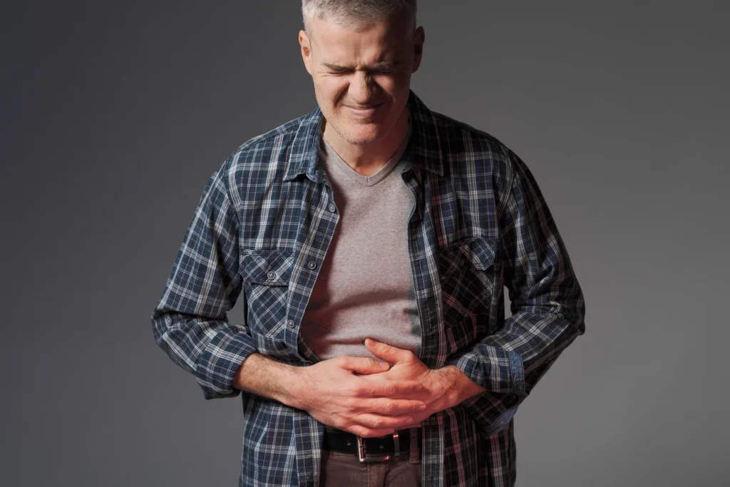 A man holding his abdomen through a bout of cramping